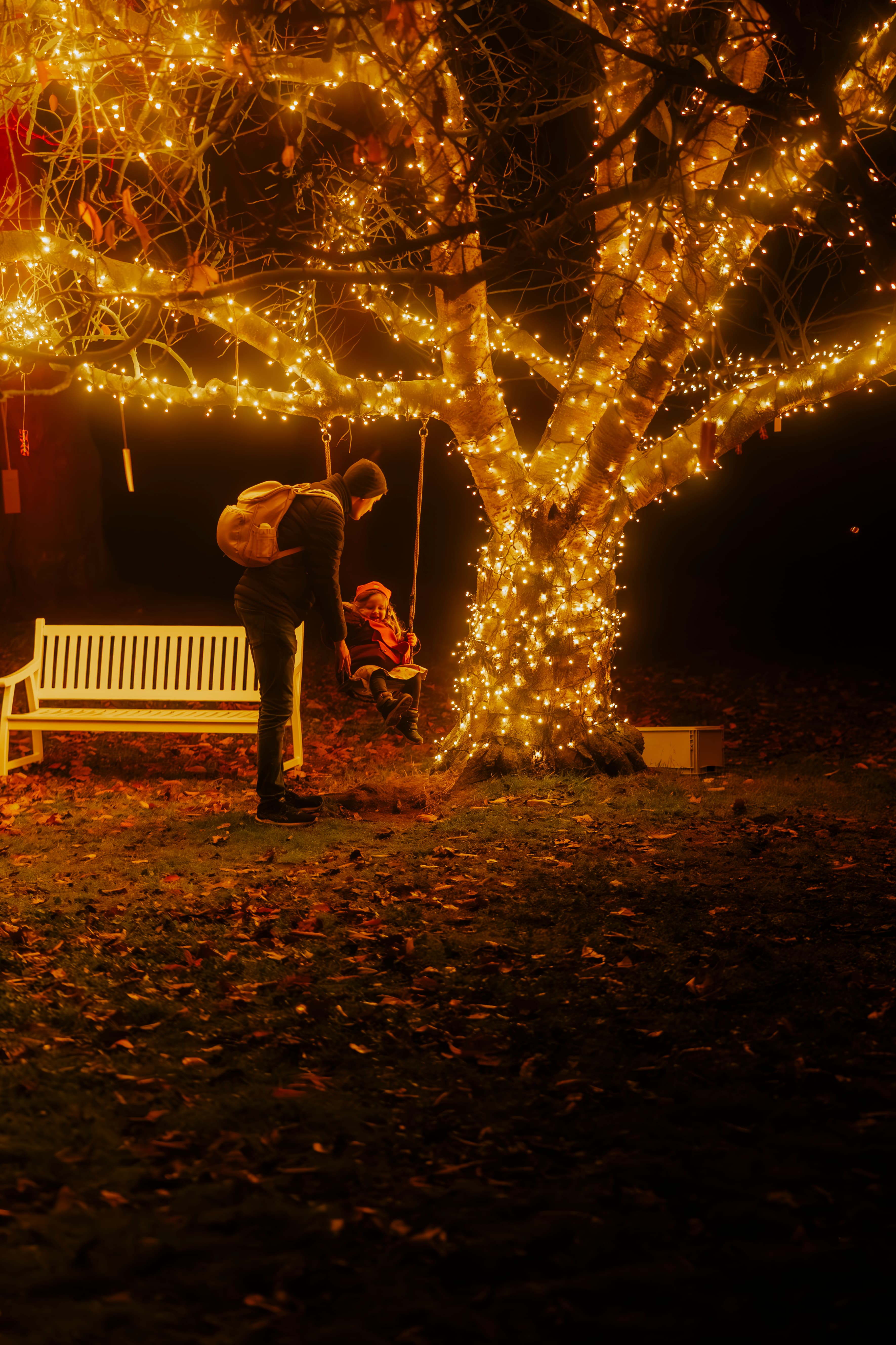 Kleines Kind auf der Schaukel beim Winterleuchten Event