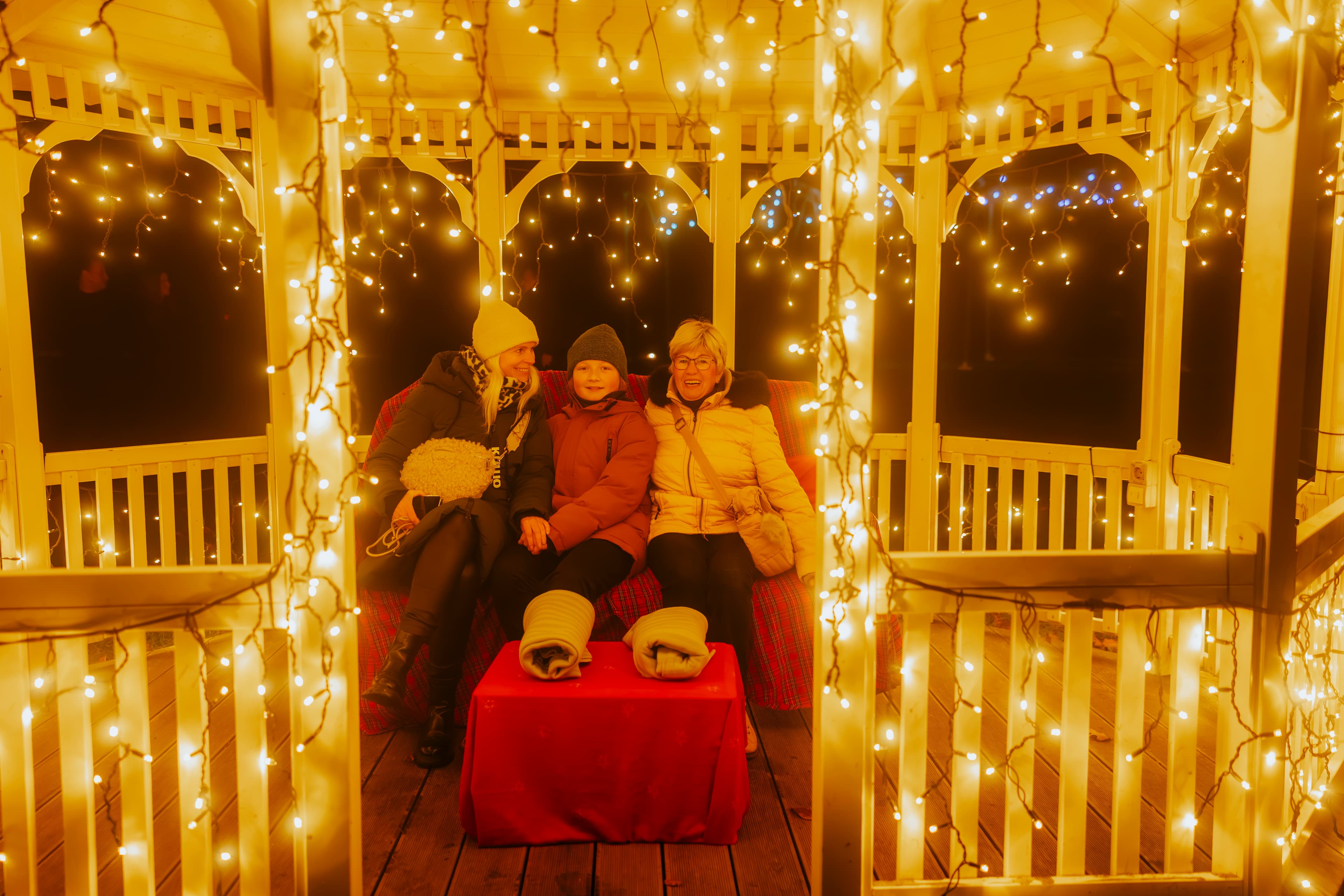 Familie sitzt im Pavillion beim Winterleuchten Event
